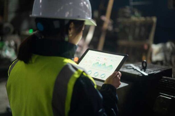 A manager in a hardhat is able to review data on fuel card usage in real-time at a jobsite.